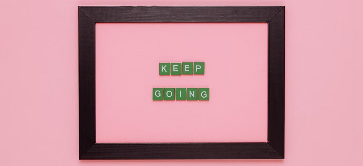 A framed motivational quote on a pink background for inspiration.