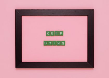 A framed motivational quote on a pink background for inspiration.